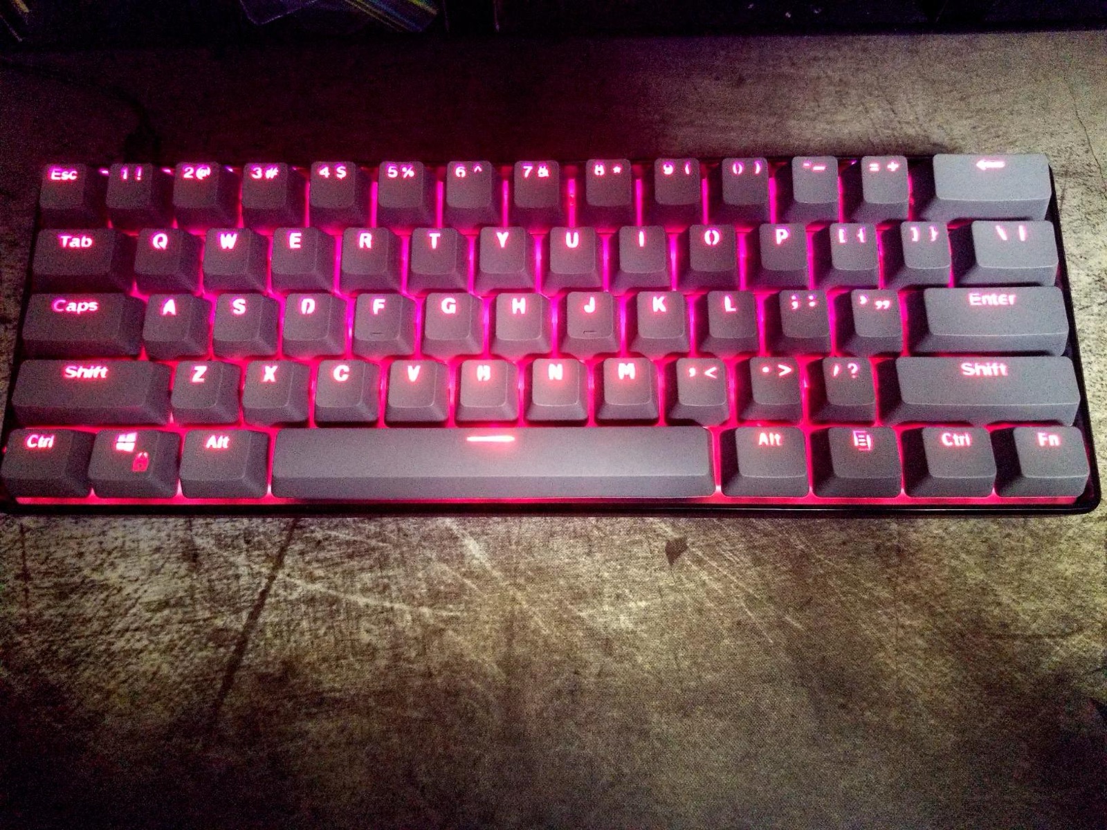 GK61 with gray keycaps and red backlighting on a wooden desk