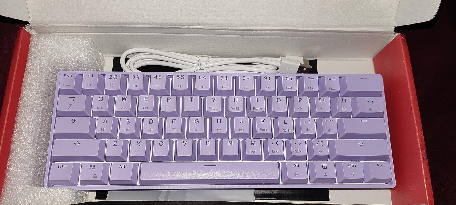 Lavender GK61 straight out of the box next to its white USB-C cable