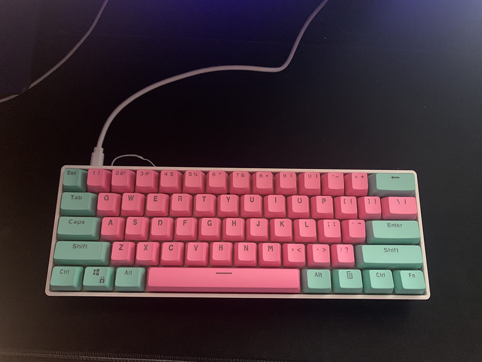 White GK61 with pink and mint keycaps and a USB-C cable